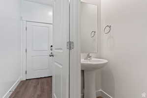 Bathroom featuring dark wood finished floors and baseboards