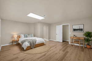 Bedroom with light wood finished floors and baseboards