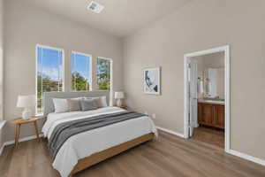 Bedroom with light wood finished floors and connected bathroom