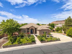 View of front of home featuring concrete driveway, stone siding, stucco siding, a garage, and a mountain view
