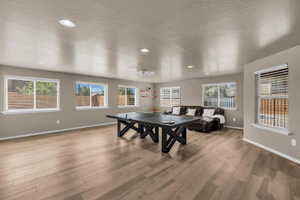 Game room with a textured ceiling, light wood-style flooring, recessed lighting, and ceiling fan