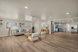 Living room featuring ceiling fan, light wood finished floors, and recessed lighting