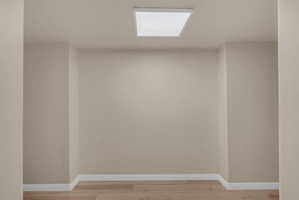 Spare room with baseboards and light wood-style floors