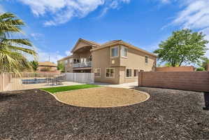 Rear view of property with a balcony, a fenced backyard, stucco siding, and a patio area
