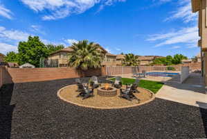 Fenced backyard featuring a patio, an outdoor fire pit, and a residential view
