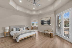Bedroom with access to outside, light wood finished floors, recessed lighting, a ceiling fan, and arched walkways