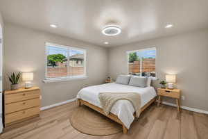 Bedroom featuring recessed lighting, light wood-style floors, and multiple windows