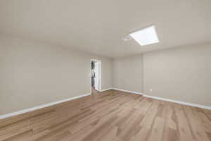 Spare room featuring light wood-type flooring and baseboards