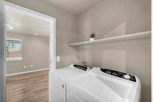 Laundry area featuring light wood-type flooring and washer and dryer