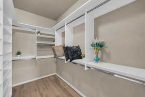 Walk in closet with light wood finished floors