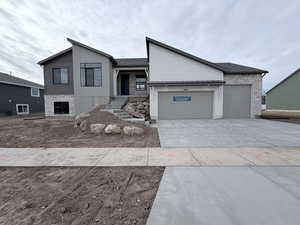 View of front facade featuring concrete driveway and an attached garage