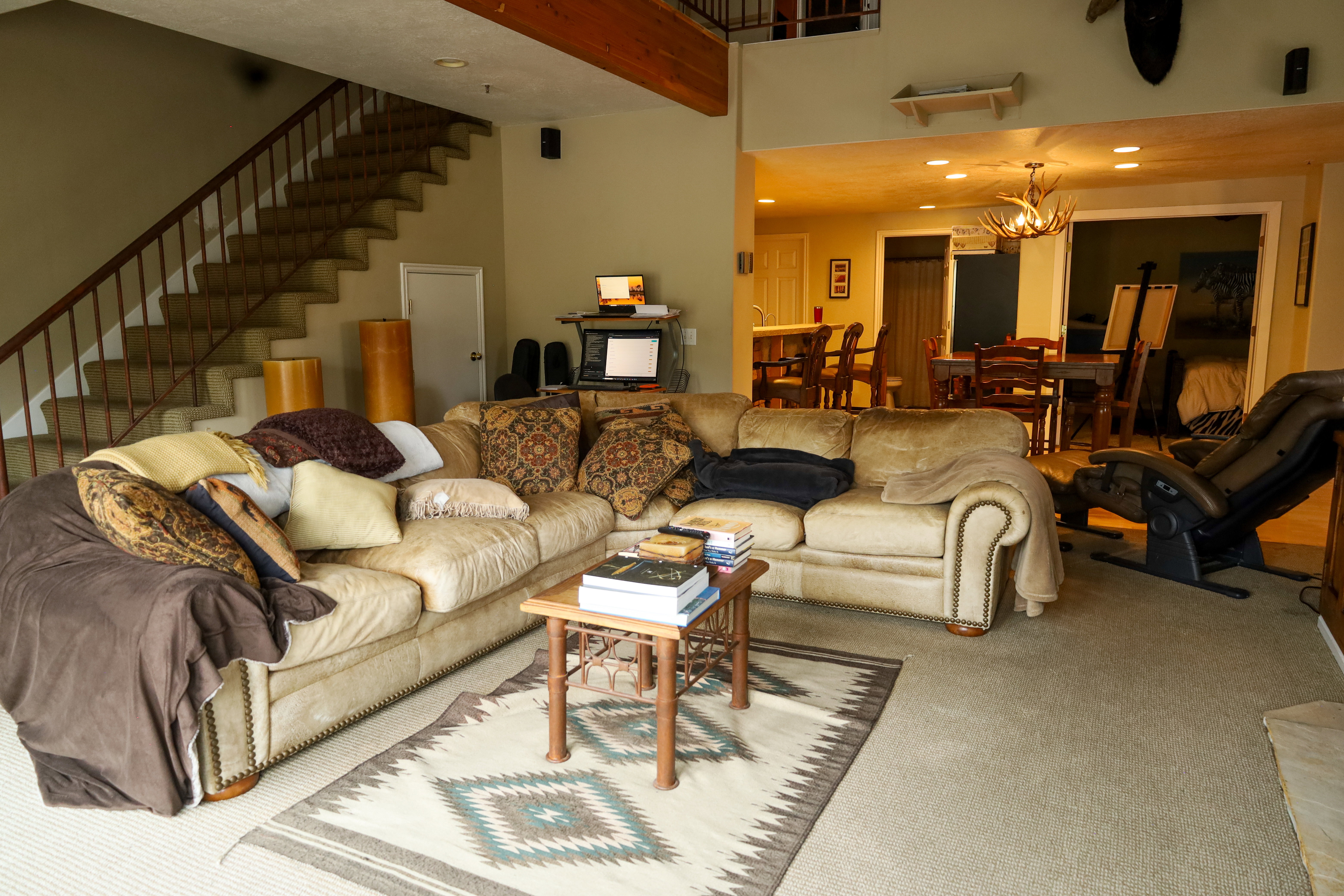 Living area with carpet floors, a chandelier, and a high ceiling