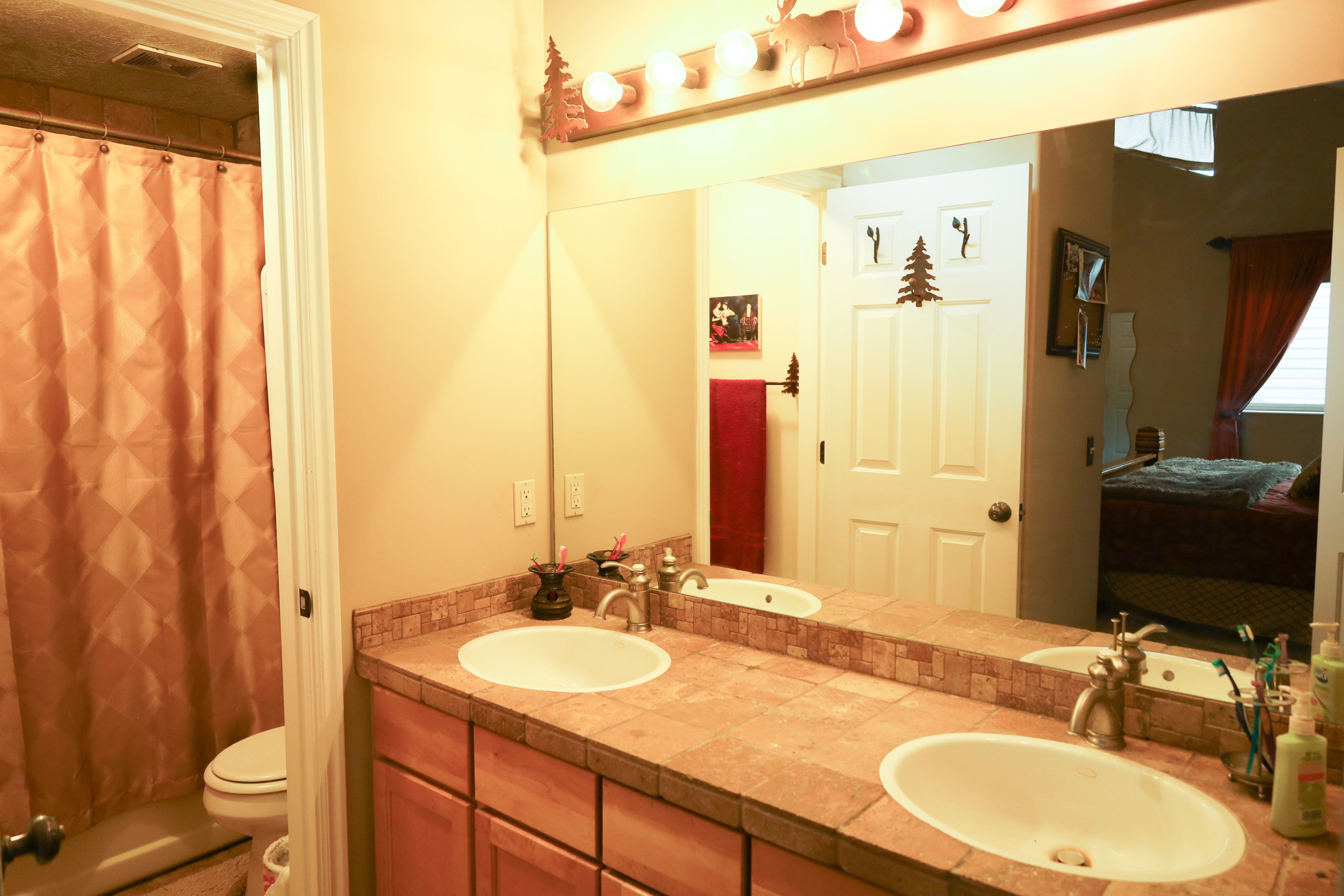 Full bath with double vanity, ensuite bathroom, and a shower with curtain