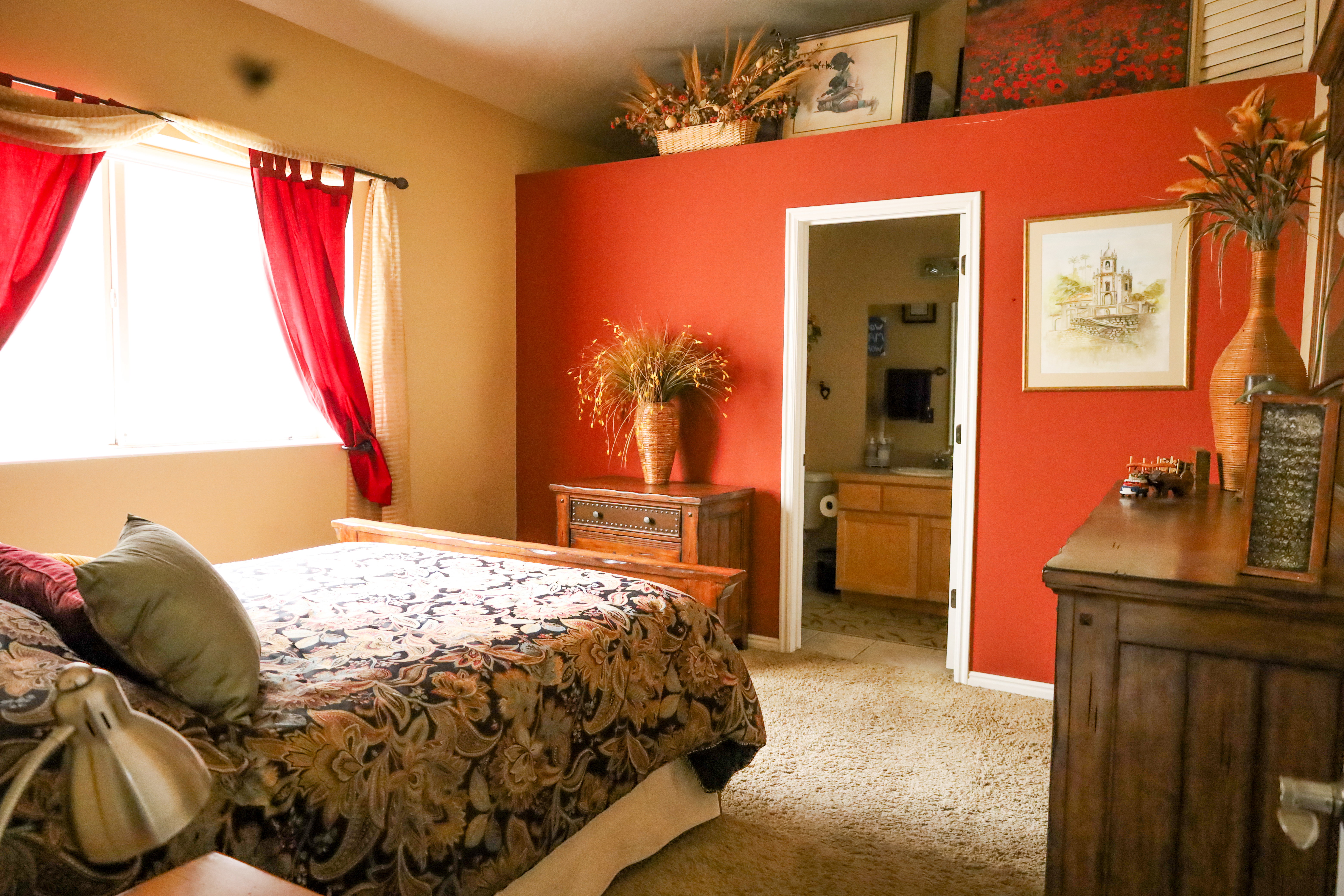 Bedroom featuring light colored carpet and connected bathroom
