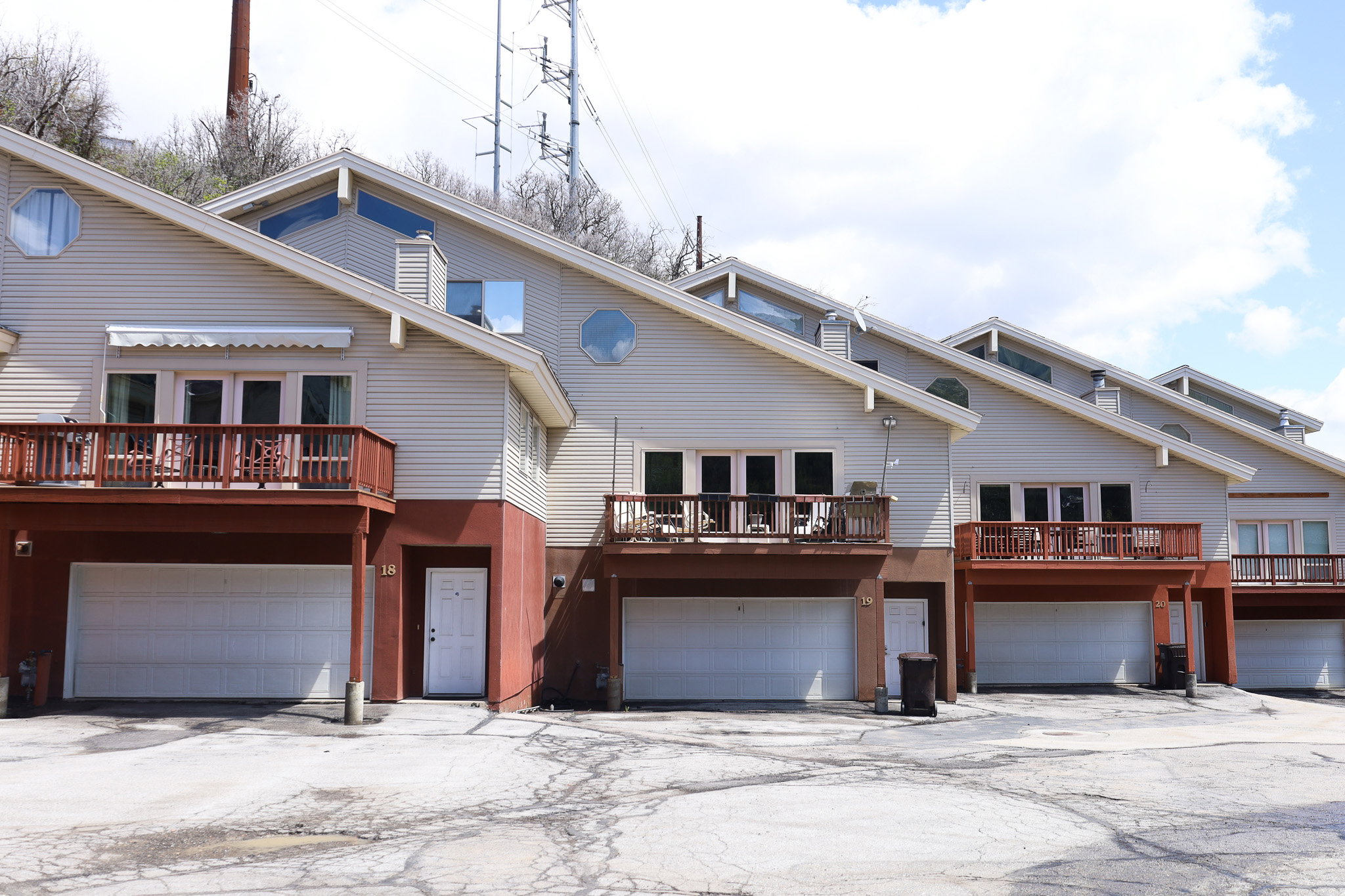 Back of house with a garage, a balcony, and driveway
