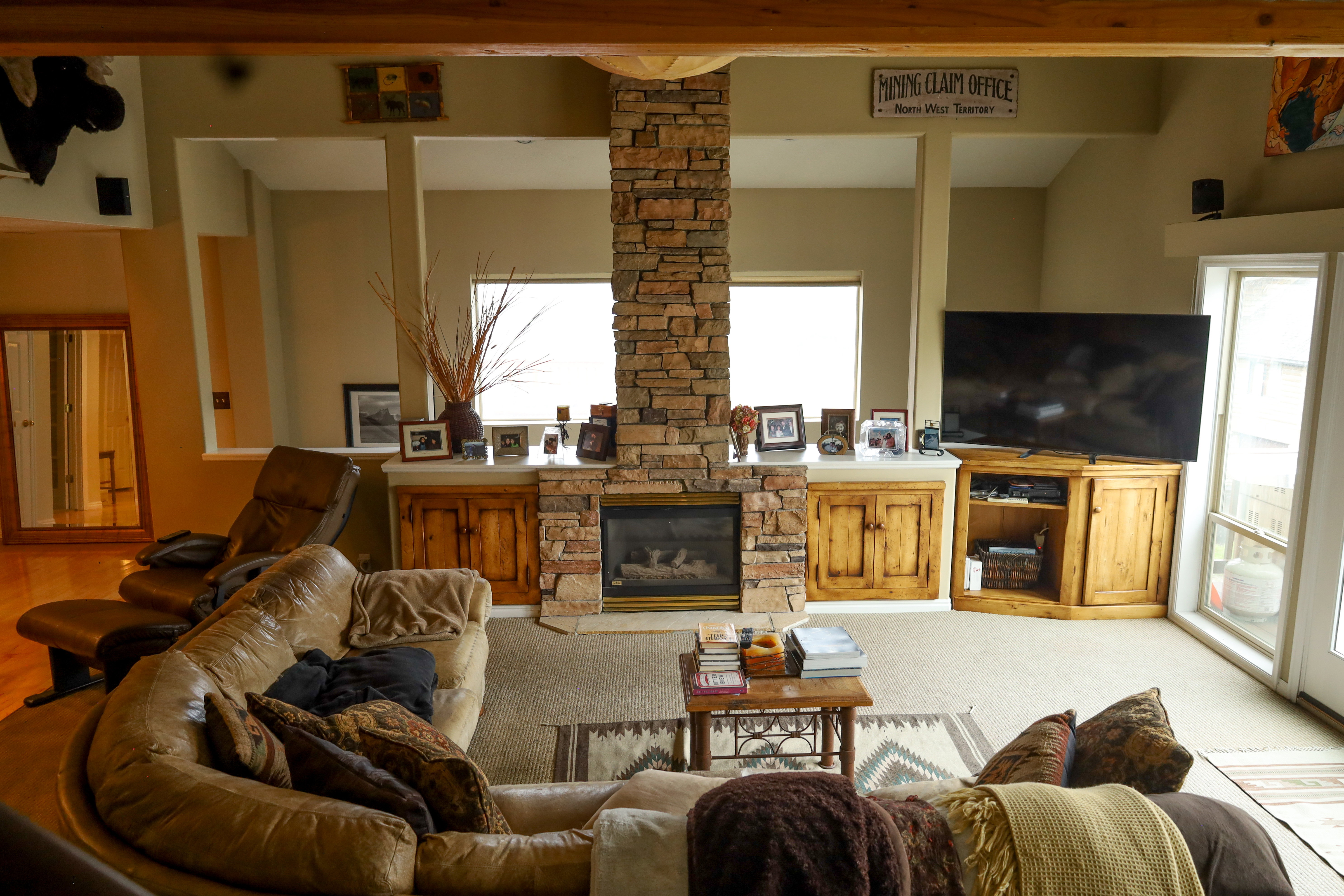 Living room with a stone fireplace and carpet floors