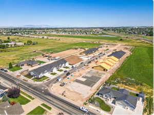 Aerial view of property and surrounding area featuring nearby suburban area and a large body of water
