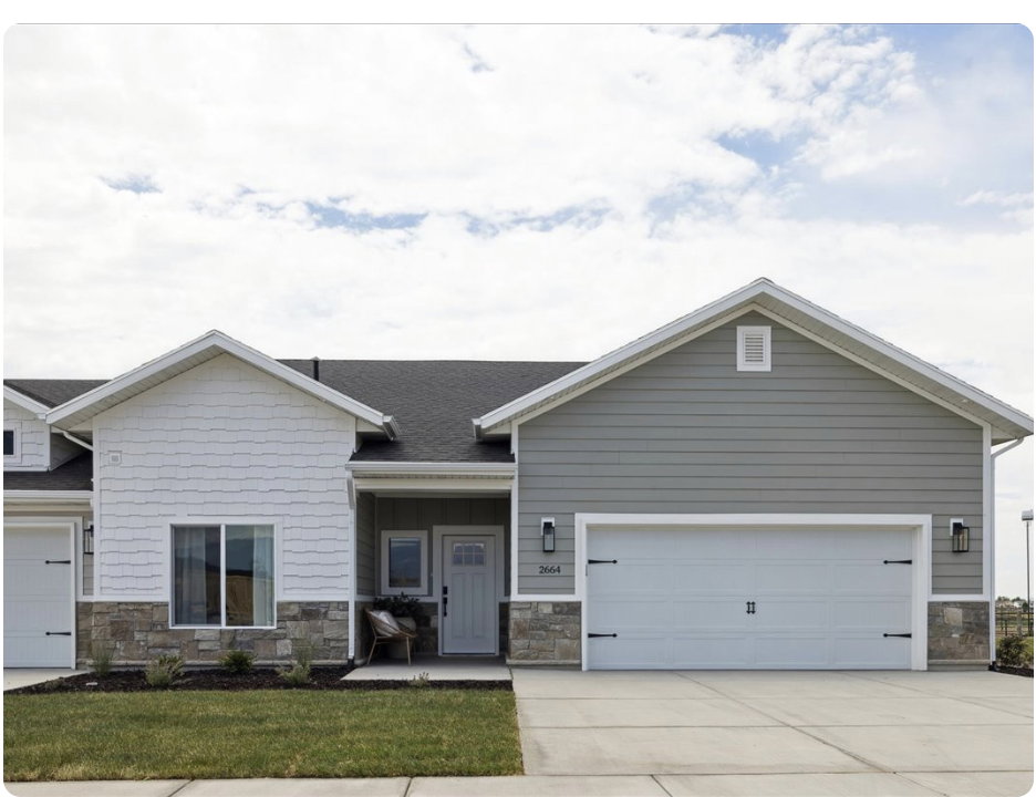 Craftsman-style house featuring stone siding, a garage, driveway, roof with shingles, and a front yard