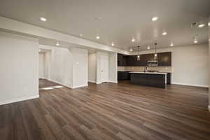 Unfurnished living room with recessed lighting and dark wood-style flooring