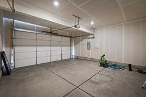 Garage featuring electric panel and a garage door opener