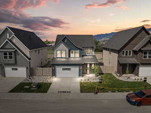 View of front facade with a gate, an attached garage, concrete driveway, and board and batten siding