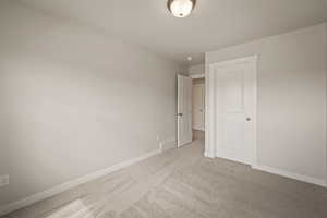 Spare room featuring baseboards and light colored carpet