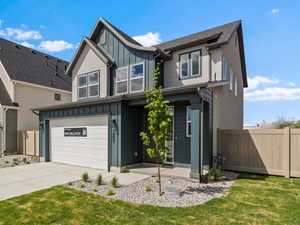 Craftsman-style home with board and batten siding, concrete driveway, and an attached garage