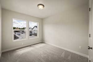 Spare room featuring light carpet and baseboards