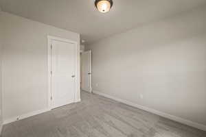 Spare room with light carpet and baseboards