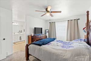 Bedroom with a textured ceiling, ceiling fan, and light colored carpet
