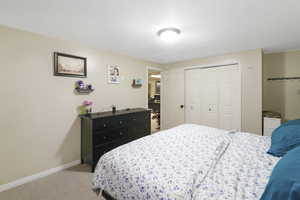 Bedroom featuring light colored carpet and a closet