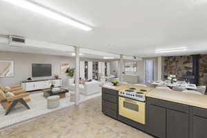 Kitchen featuring open floor plan, light countertops, range with electric cooktop, a wood stove, and a textured ceiling