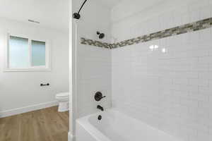 Full bathroom with crown molding, light wood-type flooring, and shower / bathtub combination