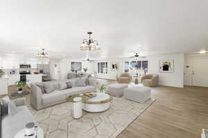 Living area featuring a ceiling fan, a chandelier, and light wood-style flooring
