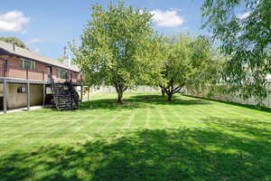 Fenced yard featuring stairs and a deck