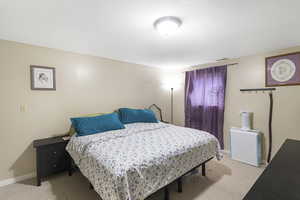 Bedroom featuring light carpet and baseboards