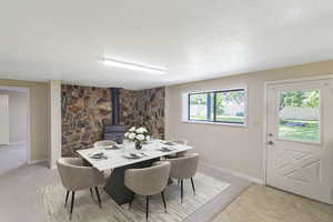 Dining room featuring a wood stove and a textured ceiling