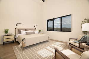 Bedroom with light wood-style flooring, vaulted ceiling, and ceiling fan