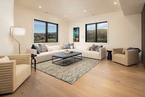 Living room featuring light wood-style flooring, recessed lighting, and plenty of natural light
