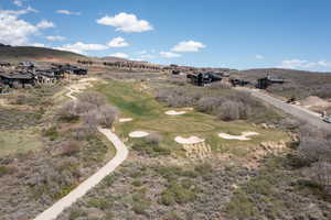 Aerial perspective of suburban area with a mountain backdrop and a golf club