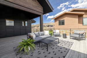 Wooden deck with outdoor seating and a mountain view