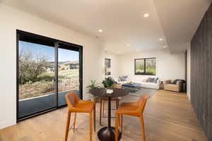 Dining room featuring light wood-style flooring, healthy amount of natural light, and recessed lighting