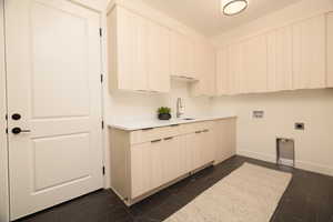Laundry room featuring hookup for a washing machine, dark marble finish floors, electric dryer hookup, and cabinet space