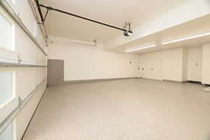 Garage featuring baseboards and a garage door opener