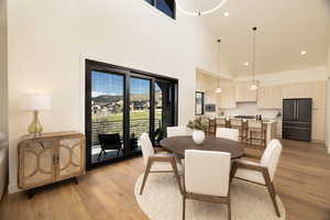 Dining room with recessed lighting, light wood finished floors, and lofted ceiling