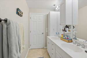 Full bath featuring double vanity and light tile patterned flooring
