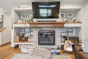 Living area featuring a tiled fireplace and wood finished floors