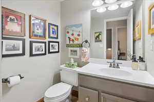 Half bathroom with vanity and a textured wall
