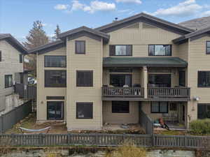 Rear view of property featuring a fenced backyard and a balcony