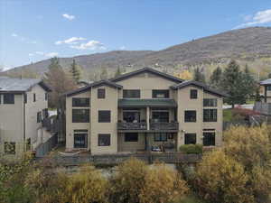 Rear view of property with a balcony and a mountain view